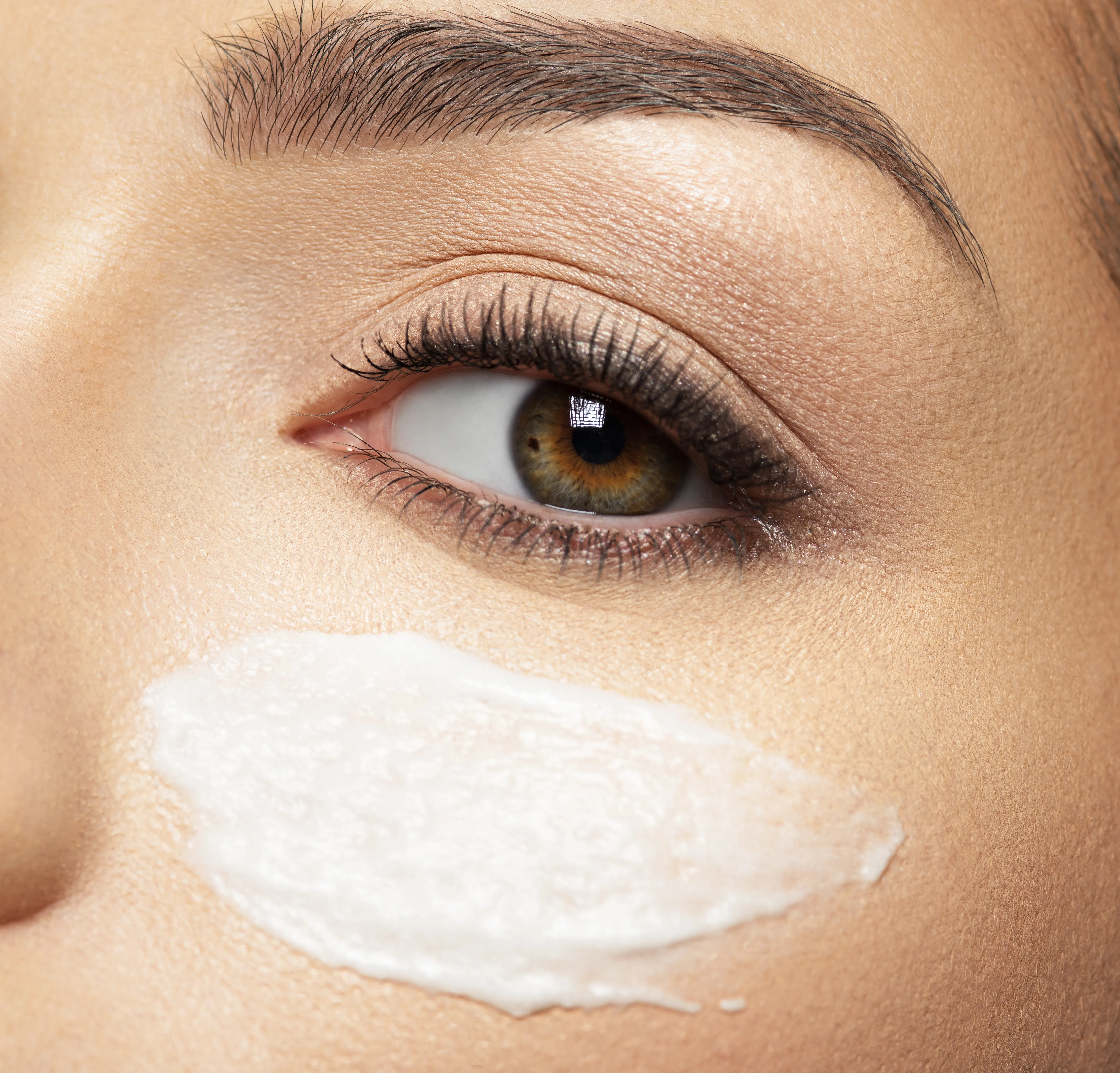 woman with skincare serum under her eye