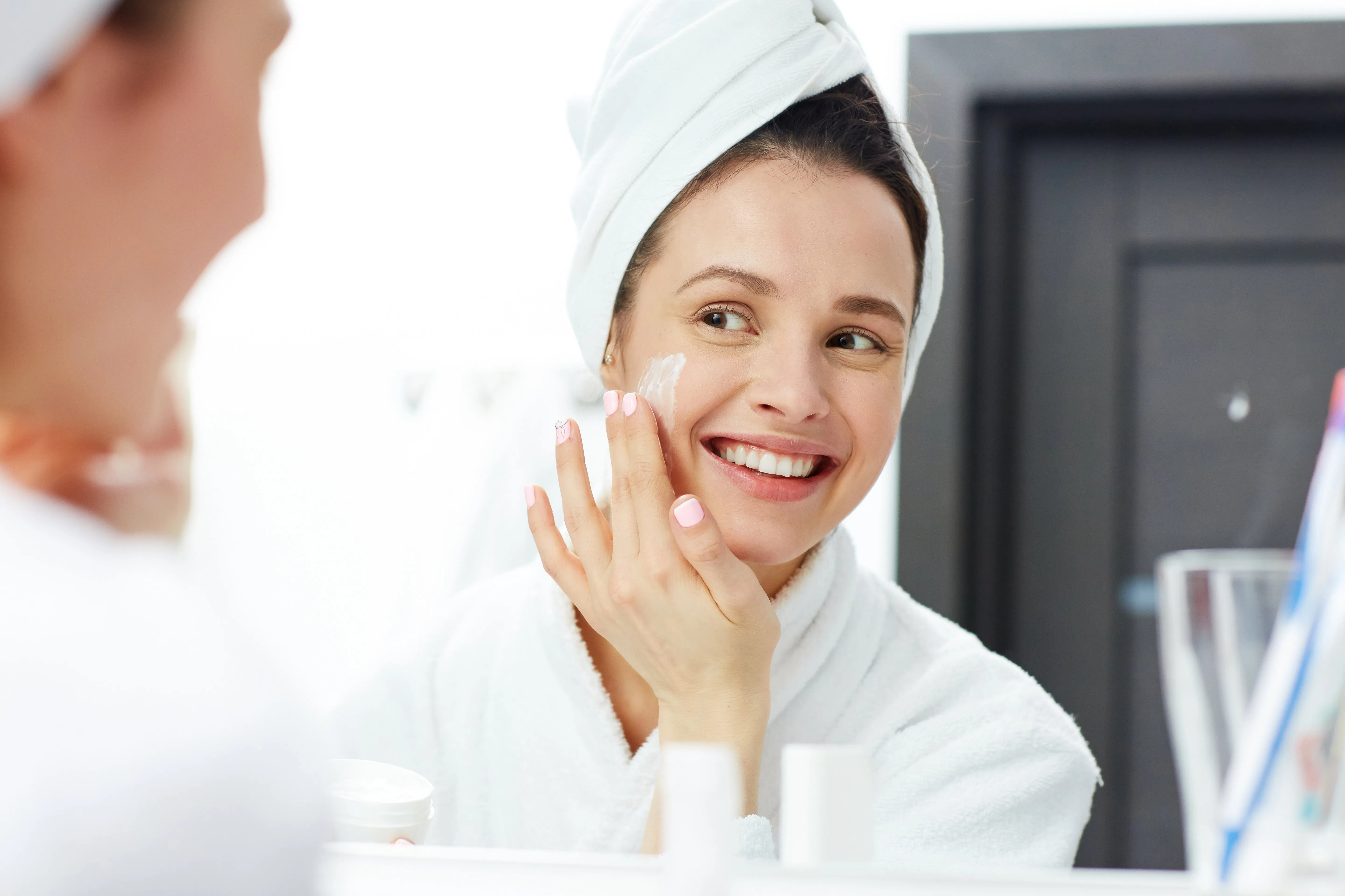 woman in a bathroom applying skincare